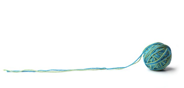 彩色棉线球由两种颜色的绿、蓝线隔离在白色的背景上。图片下载
