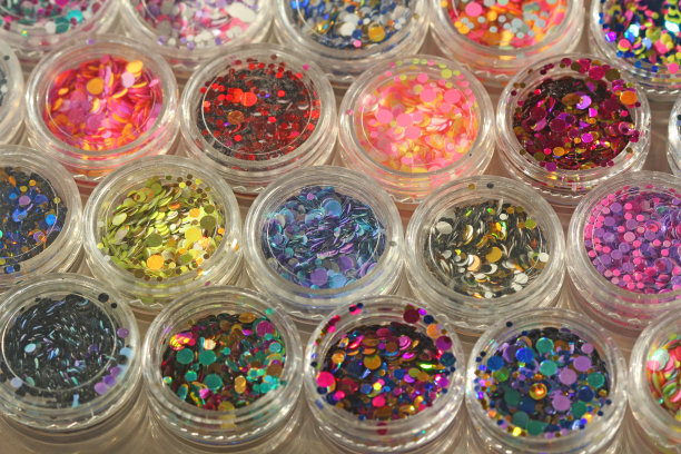 多色亮片设计的钉子在一个罐子。在jar闪闪发光。指甲用锡箔。组照片。闪闪美丽，闪闪发光。明亮的背景闪光。俯视图图片下载