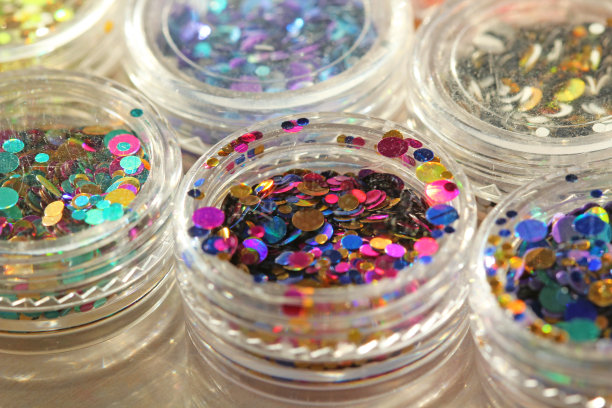 多色亮片设计的钉子在一个罐子。在jar闪闪发光。指甲用锡箔。组照片。闪闪美丽，闪闪发光。明亮的背景闪光。俯视图图片下载