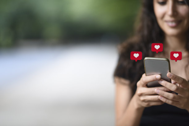 年轻女子使用带有社交媒体符号的智能手机图片下载