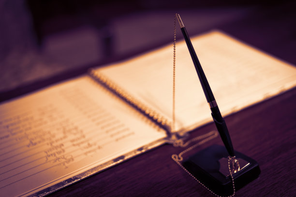 钢笔和笔记本放在一张木桌上。图片下载