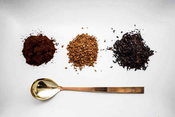 一杯天然咖啡，一杯速溶咖啡，一杯茶和一把勺子放在桌上图片下载