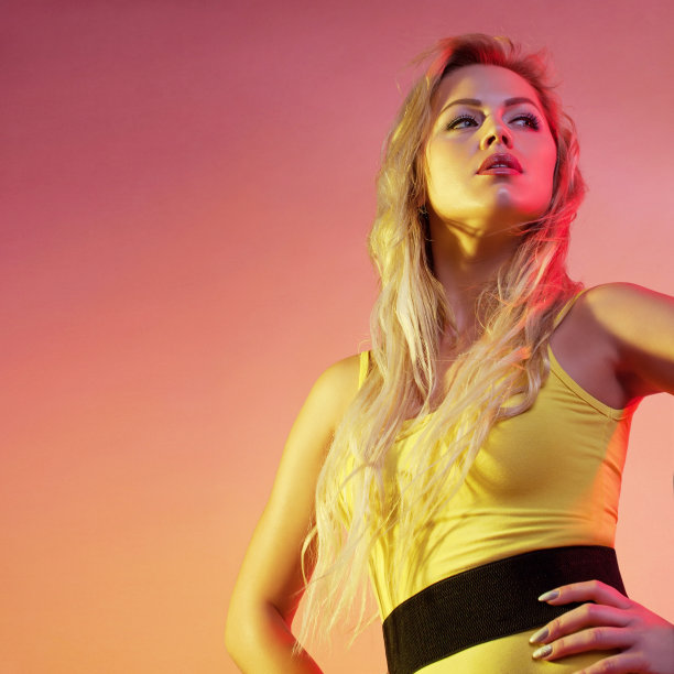 迷人的女人在色彩鲜艳的灯光下。图片下载