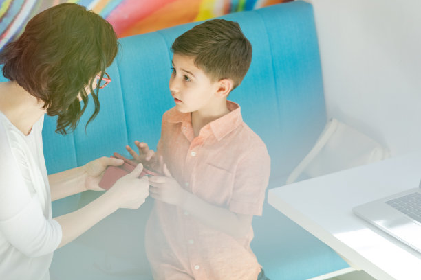 一个女人给一个男孩使用智能手机的指导图片下载