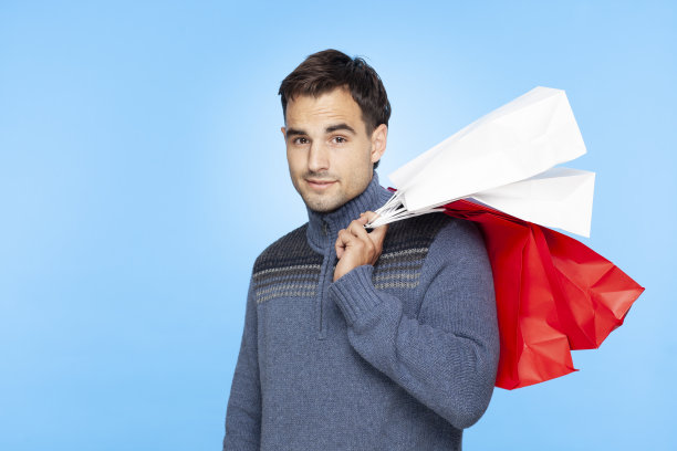 肩扛购物袋的英俊男人，冬季圣诞季图片下载