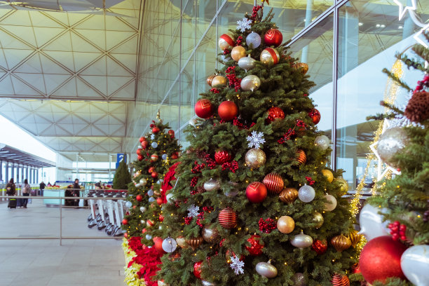 机场圣诞装饰。香港国际机场离境区外。用球，雪花，花环装饰的圣诞树线。背景中不认识的人。图片下载