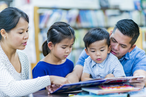 全家一起在图书馆看书。图片下载