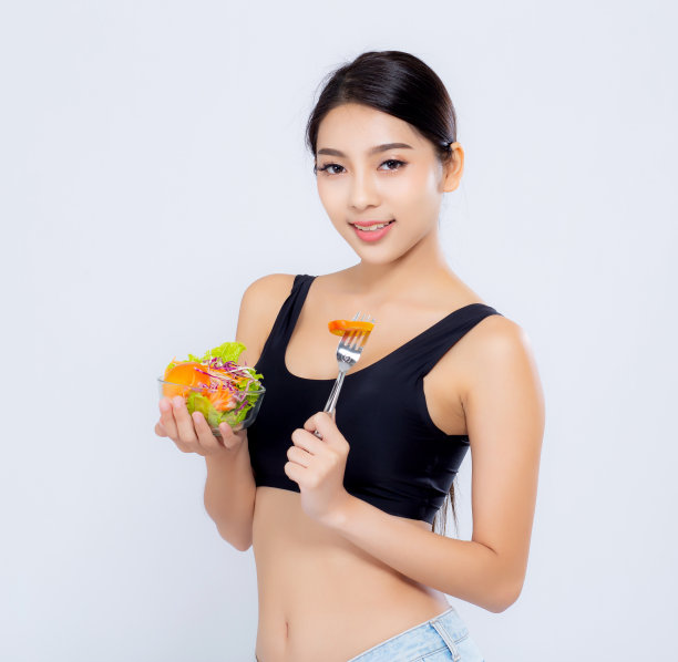 美丽的肖像年轻的亚洲妇女微笑着拿沙拉蔬菜食物孤立在白色的背景，女孩饮食吃素食的健康，保健或健康的概念。图片下载