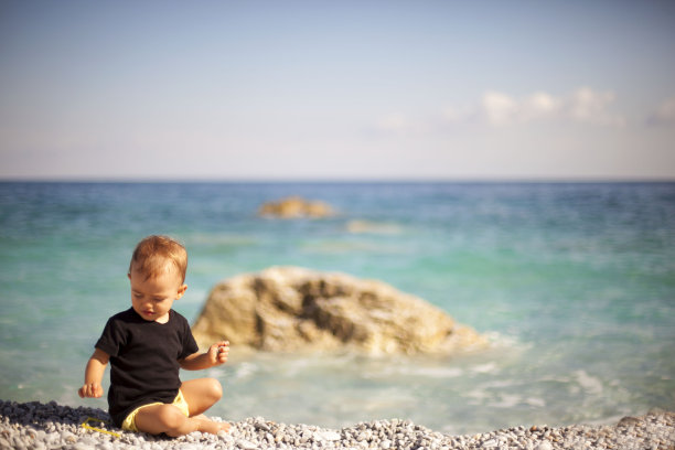 夏天，可爱的小宝贝在沙滩上玩耍图片下载