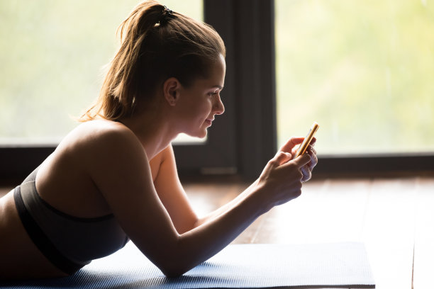 年轻的运动女性用智能手机或应用程序发短信图片下载