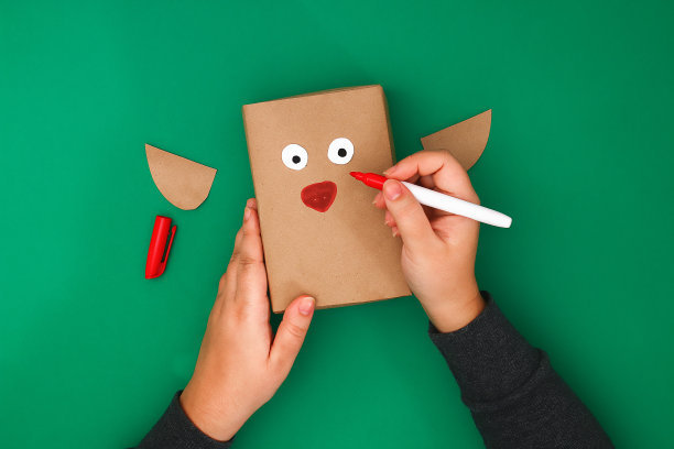 用牛皮纸制作的绿色背景鹿的圣诞礼物的原始设计。一步一步在照片上。手工制作的,DIY。鹿的礼物。图片下载