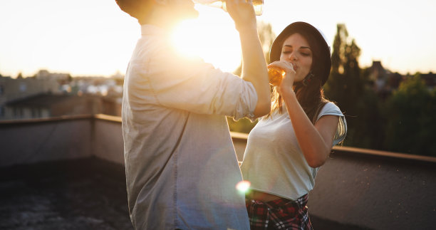 快乐的小情侣在阳台上喝酒图片下载