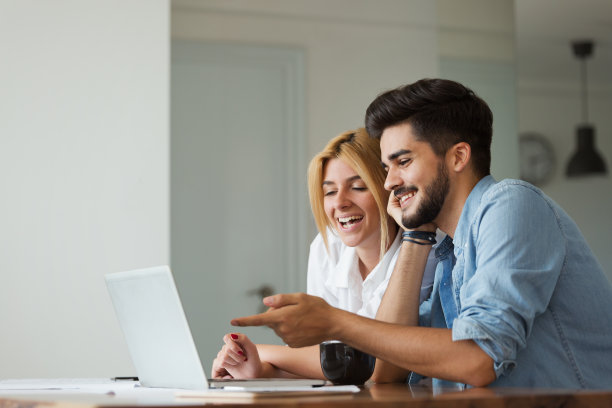 英俊的年轻人和迷人的女人在电脑上工作图片下载