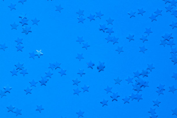 亮蓝色背景上的蓝色亮片，五彩纸屑作为星号。图片下载