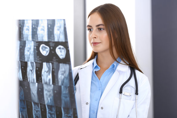 一位女医生站在医院窗户附近检查x光照片。在工作中的外科医生或整形外科医生医疗保健理念图片下载