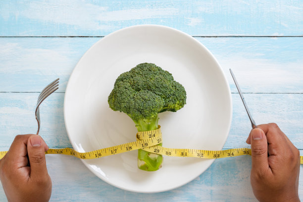 顶视图的新鲜'nBlock克里在白色盘子和测量磁带在蓝色木制背景。饮食的概念。图片下载