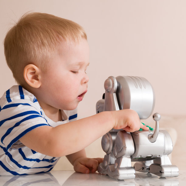 一个蹒跚学步的小男孩在玩电子狗。图片下载