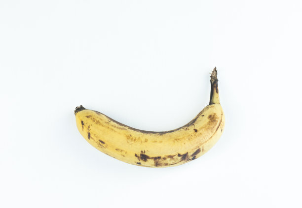 成熟的香蕉果实黄色，成熟的香蕉与黑色斑点在白色的背景与修剪路径。图片下载