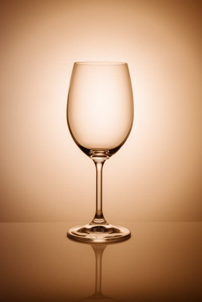 空酒杯孤立在橙色的灯光背景上。图片下载