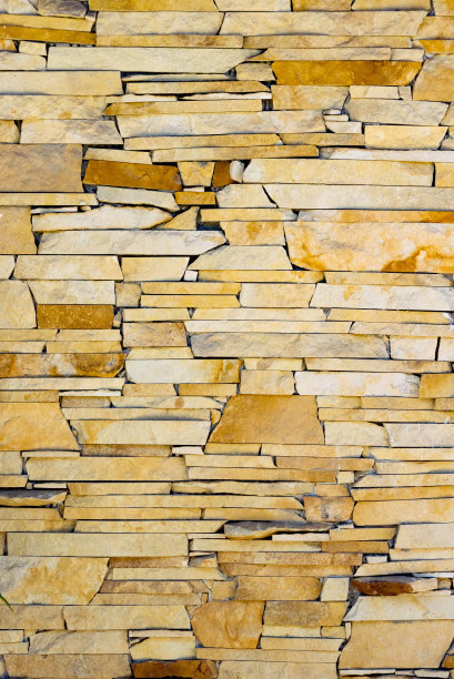 由装饰性石头制成的墙壁的垂直照片。最好的背景图片下载