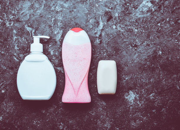 一套淋浴产品在黑色的混凝土表面。肥皂，洗发水，沐浴露。副本的空间。一组用来保持自身卫生的物品。前视图。平躺图片下载