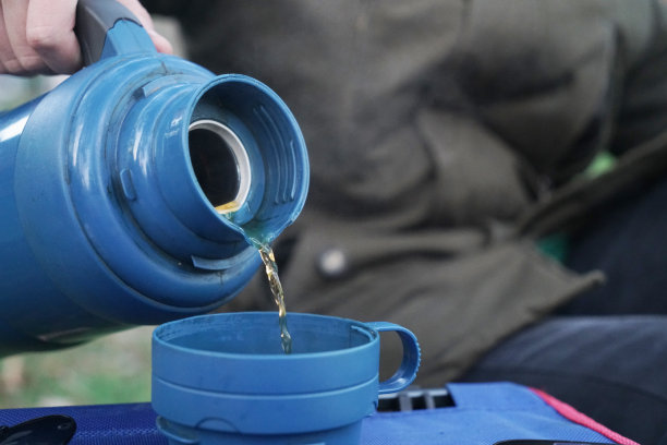 男人女人的拿着蓝色水壶，倒着热茶图片下载