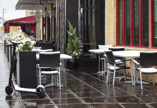 个人机动电动车停在废弃的人行道咖啡馆在雪天-红色和黑色修剪图片下载