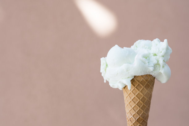 白色冰淇淋的蛋筒，以粉红色为背景图片下载