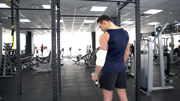 肌肉发达的男子肘部受伤，在运动俱乐部用哑铃训练，恢复图片下载