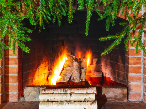 在用云杉树枝装饰的壁炉里燃烧木柴图片下载