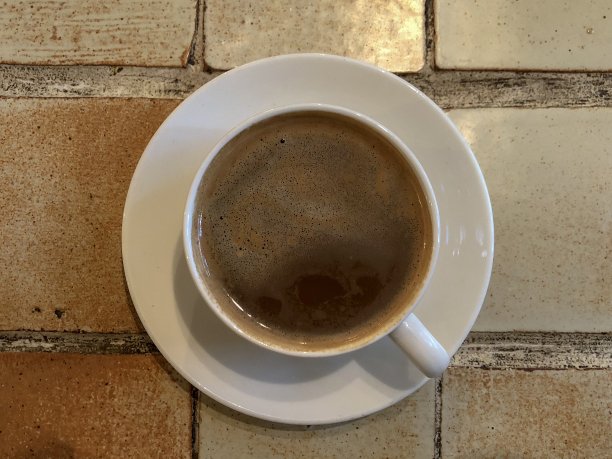 咖啡杯和茶碟放在瓷砖桌上图片下载