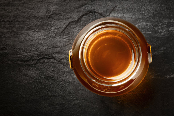 一个充满活力的有机蜂蜜罐子的照片，从顶部拍摄的黑暗背景和文字的地方图片下载