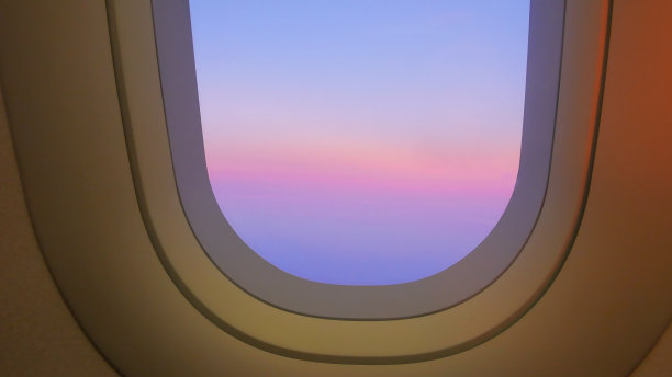 美丽的日落天空在飞机上，飞机窗户，放松飞行在一个度假的概念图片下载