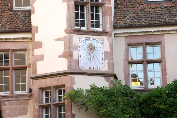 在法国阿尔萨斯的里奎威尔，墙上挂着一个日晷或太阳时钟图片下载