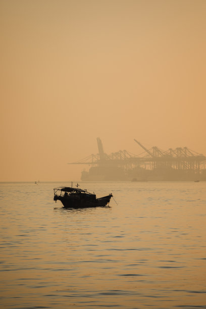 传统渔船以集装箱货港为背景图片下载