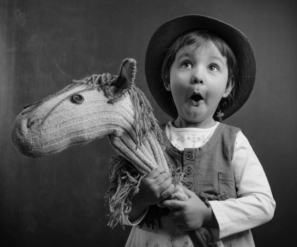 可爱的小女孩穿着牛仔装，骑着自制的马。图片下载