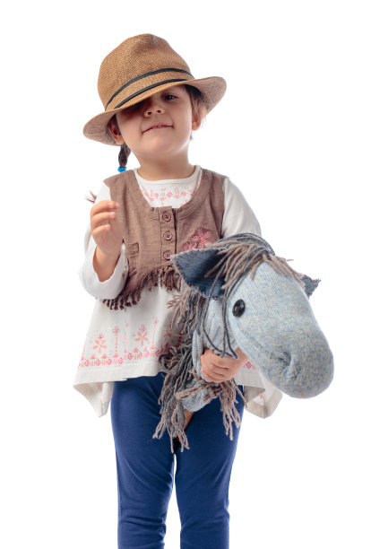 一个小女孩和一匹自制的马的肖像被孤立在白色。图片下载