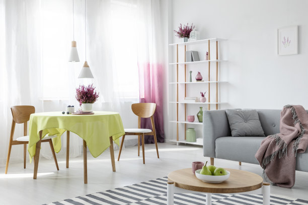 客厅和餐厅在现代公寓与灰色沙发和木制家具，真实照片图片下载