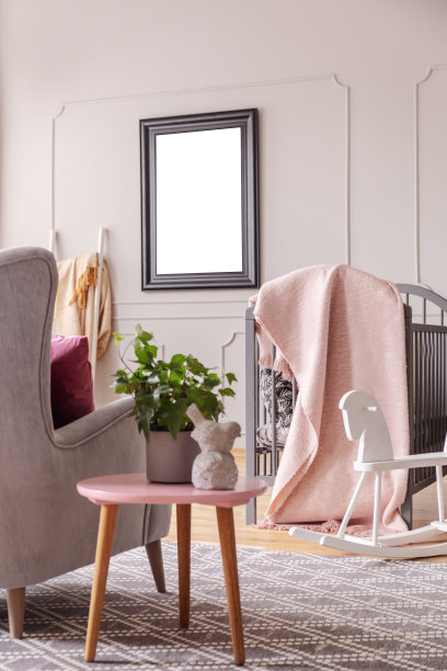 桌子与植物旁边的扶手椅在孩子的卧室内部与空白海报的模型。真实的照片图片下载