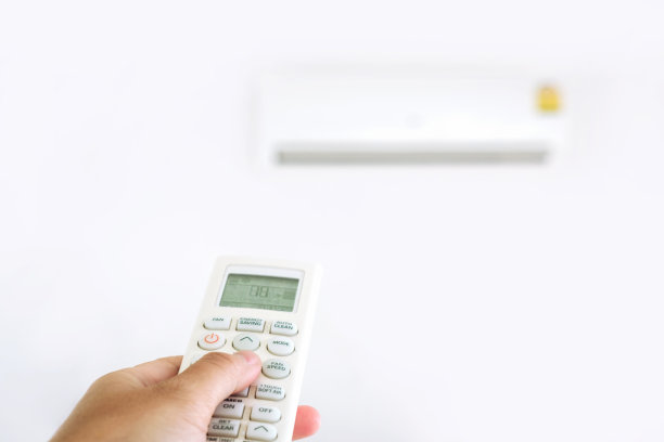 女人在家里用遥控器控制空调图片下载
