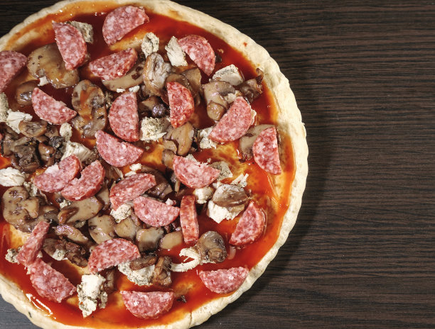 披萨烹饪，鸡肉，香肠腊肠，厚面团，披萨饼皮，披萨是在一个黑暗的桌子上，披萨与鸡肉和香肠腊肠，烹饪过程，蘑菇，香宾图片下载