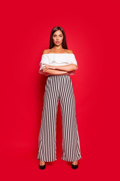 垂直的全尺寸的身体长度肖像好看的内容坦率冷静可爱可爱的漂亮的女士穿着白色的露肩上衣条纹裤子双臂孤立在柔和的红色背景图片下载