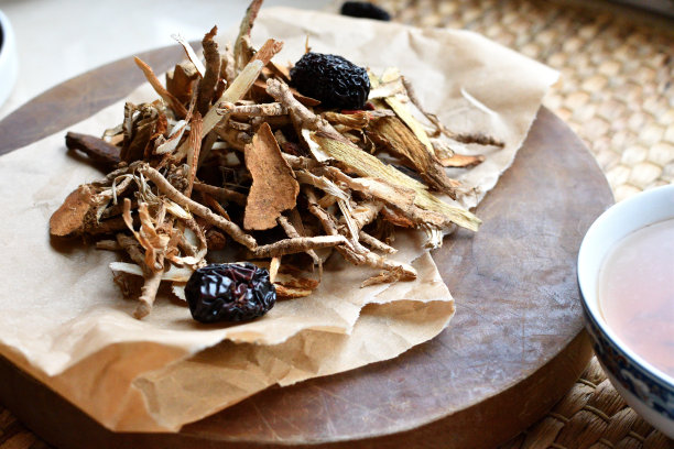 中药。用红枣、枸杞、人参等在羊皮纸上的草药茶，背景为中性。侧视图。图片下载