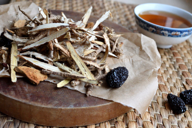 中药。用红枣、枸杞、人参等在羊皮纸上的草药茶，背景为中性。侧视图。图片下载