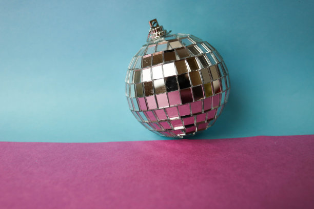 银镜音乐俱乐部迪斯科球小圆玻璃冬天闪亮装饰美丽的圣诞圣诞球，圣诞玩具贴在亮灰色粉紫色的背景上图片下载