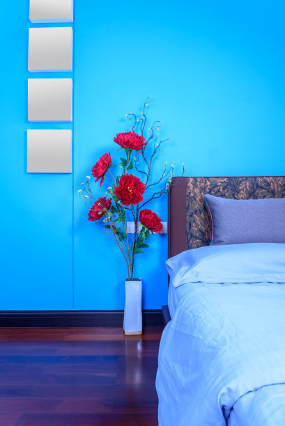现代卧室装饰，床头板和彩色的人造花花瓶在木地板上图片下载