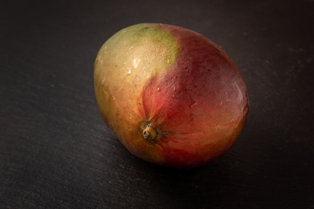 新鲜多汁的芒果孤立在一个黑色的背景图片下载