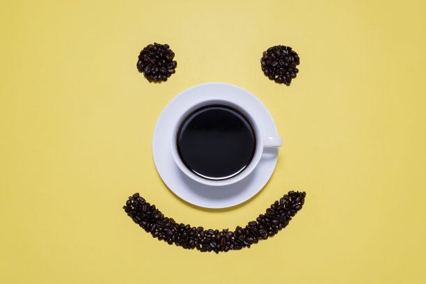 微笑的咖啡豆围绕着一杯黑咖啡图片下载