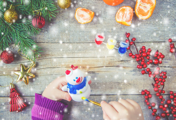 一个孩子画一个圣诞玩具，一个雪人。有选择性的重点。图片下载