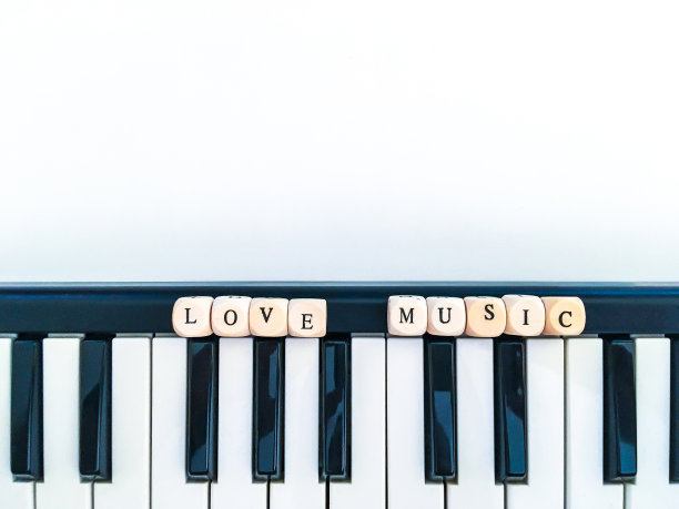 爱的音乐文本用木方的字母，在钢琴琴键的白色表面上图片下载